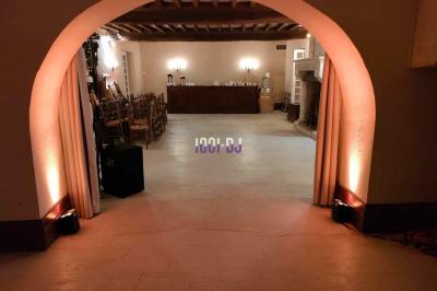 Miniature DJ Le Barp (Gironde) - Puges Flavien #7 Vue d'une salle de réception avec des tables alignées, un bar en bois et un éclairage chaleureux sous une arche.