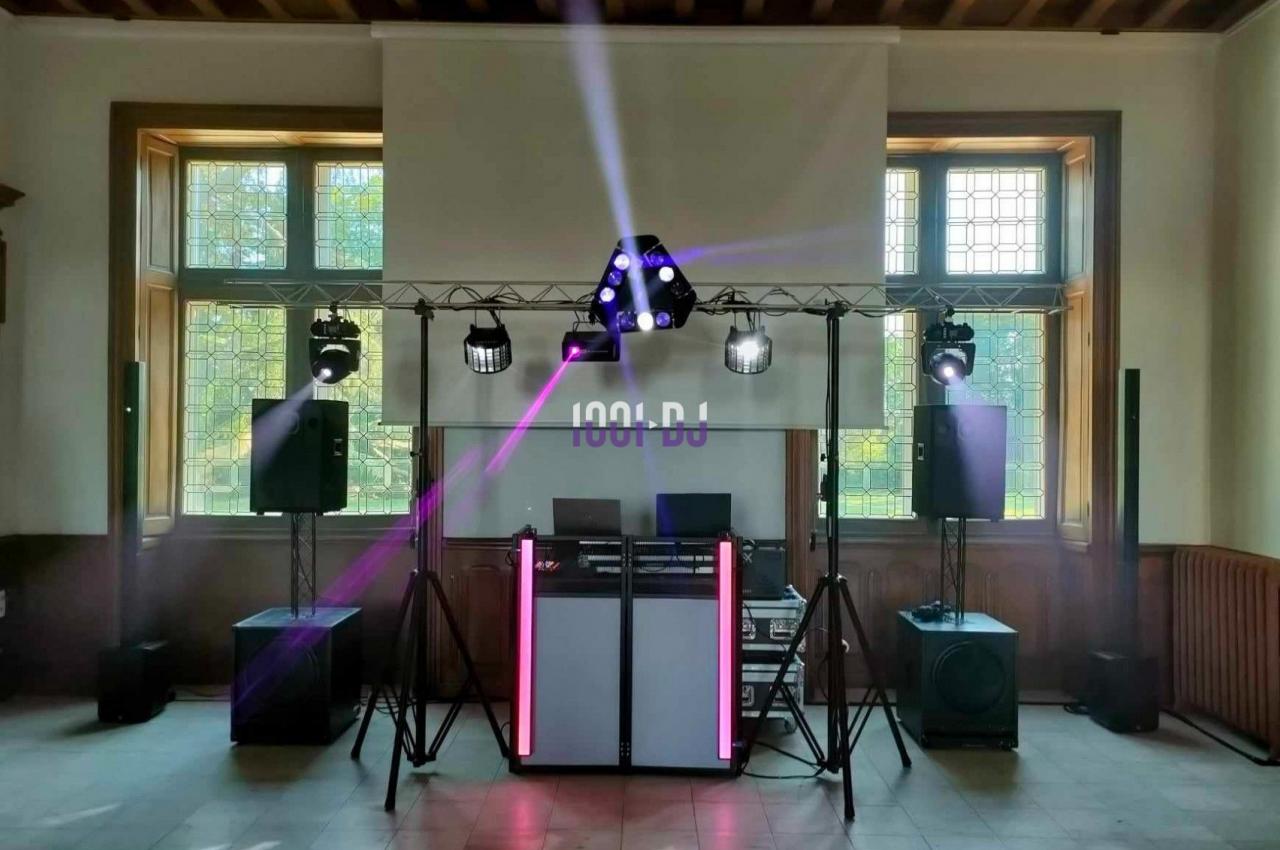 Installation de matériel de sonorisation et d'éclairage dans une salle avec projecteurs et enceintes sur pieds.