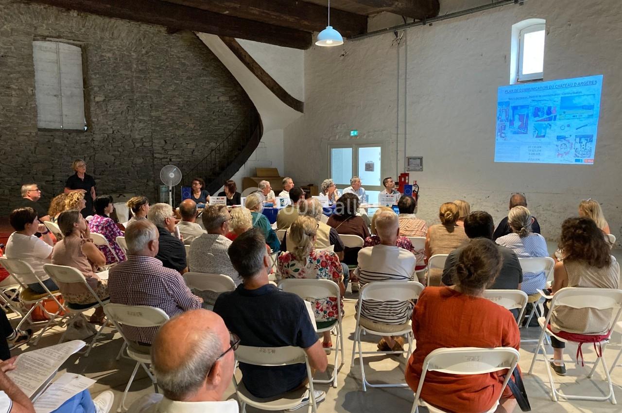 Un groupe de personnes assises dans une salle assistent à une présentation projetée sur un mur.