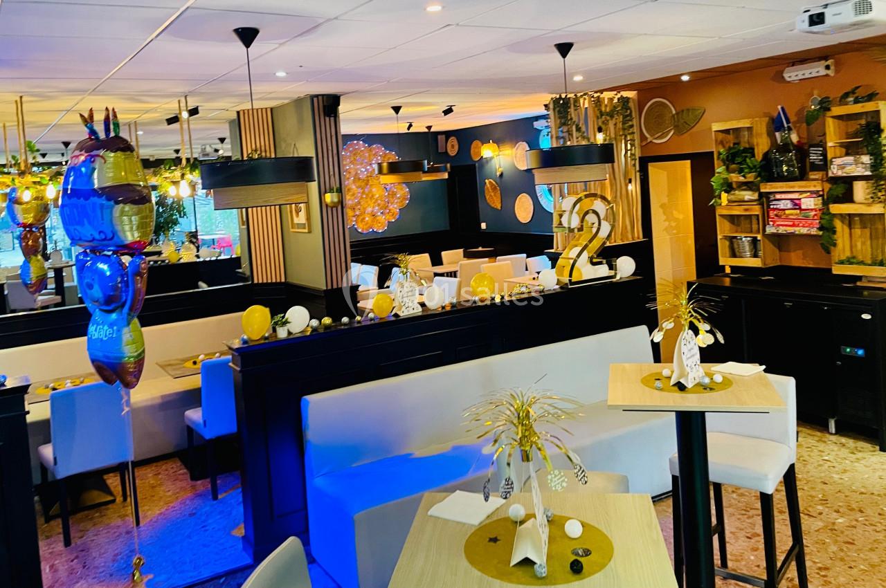 Salle de restaurant décorée avec des éléments festifs, des tables dressées et une ambiance chaleureuse.