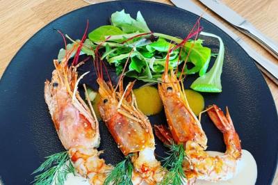 Miniature Traiteur Corbeilles (Loiret) - Abeille Royale Traiteur #7 Table de buffet décorée avec des fleurs, chandeliers allumés, coupes empilées et divers plats dans une ambiance lumineuse…