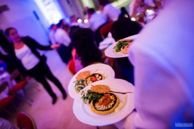 Miniature Traiteur Corbeilles (Loiret) - Abeille Royale Traiteur #10 Table de buffet décorée avec des fleurs, chandeliers allumés, coupes empilées et divers plats dans une ambiance lumineuse…