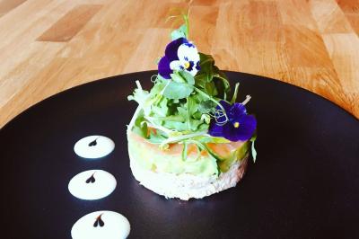 Table décorée pour un buffet avec chandeliers, fleurs, coupes empilées et divers plats dans une ambiance lumineuse violette.