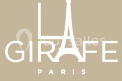 Salle décorée pour un événement avec tables rondes, nappes blanches, chaises ornées de nœuds argentés et dorés, éclairage…