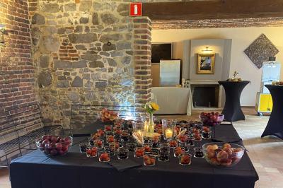 Parking en gravier entouré d'arbres et de bâtiments en briques sous un ciel partiellement nuageux.