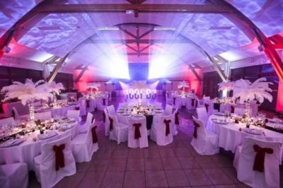 Table de mixage éclairée par des lumières colorées dans une ambiance de soirée ou de concert.