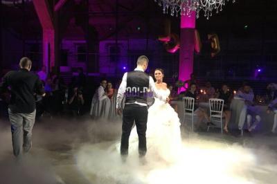 Table de mixage éclairée par des lumières colorées dans une ambiance de soirée ou de concert.