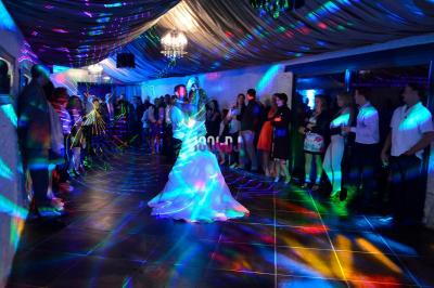Table de mixage éclairée par des lumières colorées dans une ambiance de soirée ou de concert.