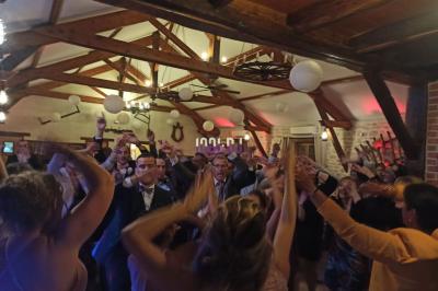 Table de mixage éclairée par des lumières colorées dans une ambiance de soirée ou de concert.