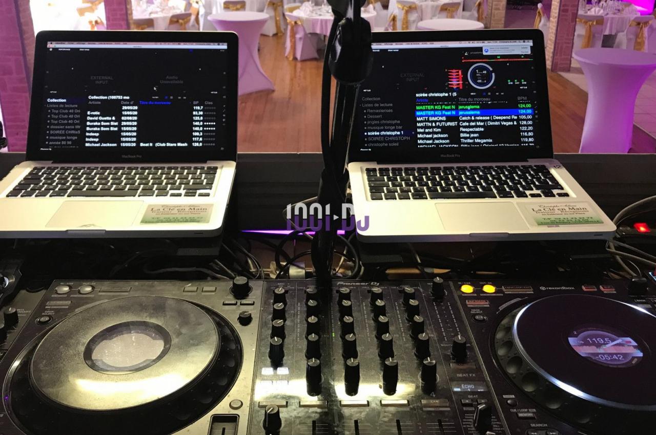 Deux ordinateurs portables et une console de mixage DJ installés dans une salle de réception.