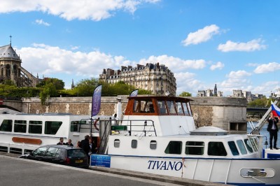Miniature Location salle Paris 16 (Paris) - Bateau Le Rêve sur Seine #5 Un capitaine en uniforme utilise une radio dans la cabine d'un bateau, avec vue sur une rivière bordée d'arbres.