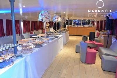 Miniature Location salle Paris 12 (Paris) - La Péniche Croisière de Bercy #3 Salle de réception sur une péniche avec tables rondes dressées, rideaux rouges et buffet de desserts au premier plan.