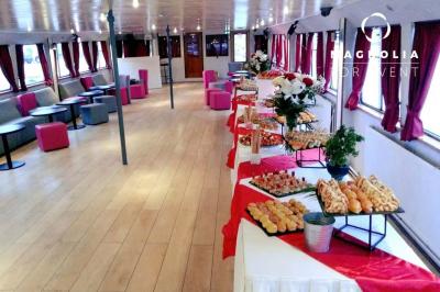 Miniature Location salle Paris 12 (Paris) - La Péniche Croisière de Bercy #6 Salle de réception sur une péniche avec tables rondes dressées, rideaux rouges et buffet de desserts au premier plan.