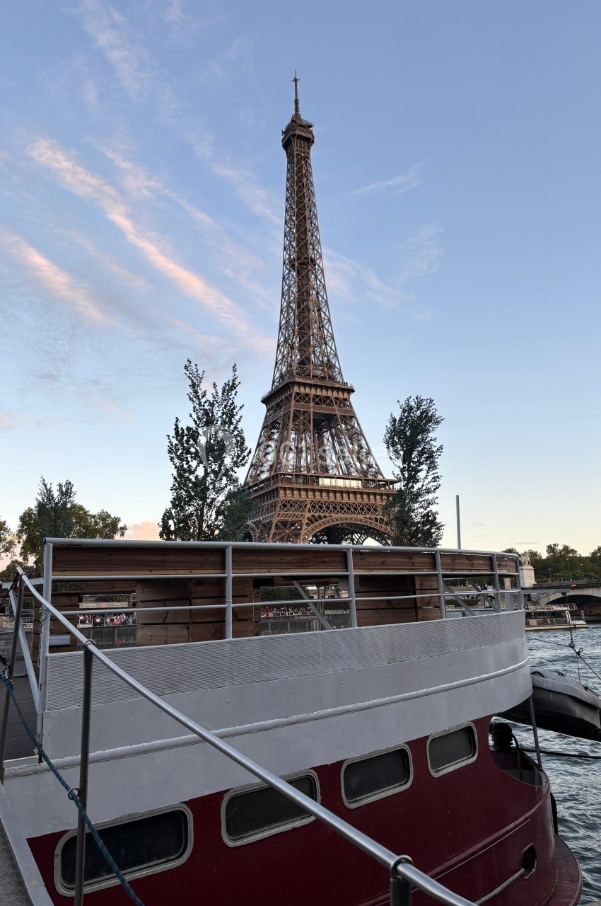 Vue de la Tour Eiffel au crépuscule depuis un bateau amarré sur la Seine.
