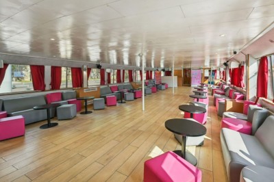 Miniature Location salle Paris 12 (Paris) - La Péniche Croisière de Bercy #16 Intérieur d'une salle spacieuse avec parquet, canapés colorés, tables rondes noires et rideaux rouges.