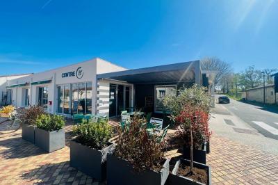 Miniature Location salle Eysines (Gironde) - Le Centre B #8 Abri en bois avec trois cibles de fléchettes fixées, une étagère avec une pomme et une autre avec un vase de fleurs.