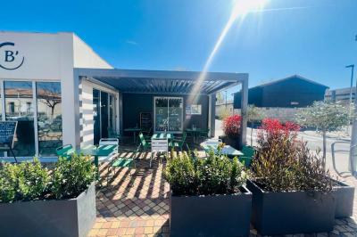 Miniature Location salle Eysines (Gironde) - Le Centre B #9 Abri en bois avec trois cibles de fléchettes fixées, une étagère avec une pomme et une autre avec un vase de fleurs.
