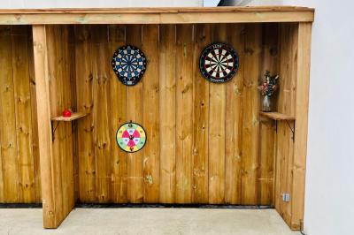 Miniature Location salle Eysines (Gironde) - Le Centre B #29 Abri en bois avec trois cibles de fléchettes fixées, une étagère avec une pomme et une autre avec un vase de fleurs.