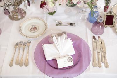 Un groupe de personnes en tenue de cérémonie tient des fumigènes colorés dans un champ ouvert.