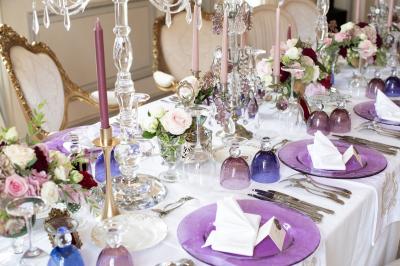 Un groupe de personnes en tenue de cérémonie tient des fumigènes colorés dans un champ ouvert.