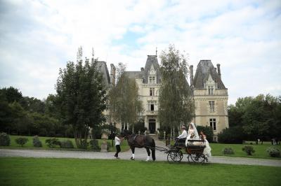 Un groupe de personnes en tenue de cérémonie tient des fumigènes colorés dans un champ ouvert.