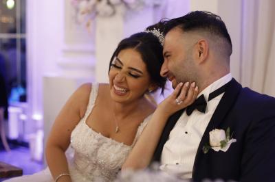 Un groupe de personnes en tenue de cérémonie tient des fumigènes colorés dans un champ ouvert.