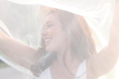 Un groupe de personnes en tenue de cérémonie tient des fumigènes colorés dans un champ ouvert.