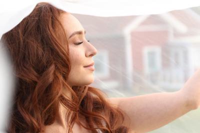 Un groupe de personnes en tenue de cérémonie tient des fumigènes colorés dans un champ ouvert.