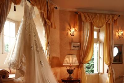 Un groupe de personnes en tenue de cérémonie tient des fumigènes colorés dans un champ ouvert.