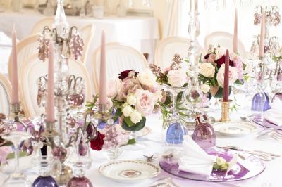 Un groupe de personnes en tenue de cérémonie tient des fumigènes colorés dans un champ ouvert.