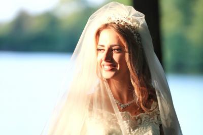 Un groupe de personnes en tenue de cérémonie tient des fumigènes colorés dans un champ ouvert.