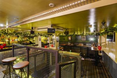 Miniature Location salle Paris 5 (Paris) - Le Pub Saint Michel #5 Salle de restaurant avec banquettes vertes, tables en bois garnies de plats variés et seau à champagne au centre.