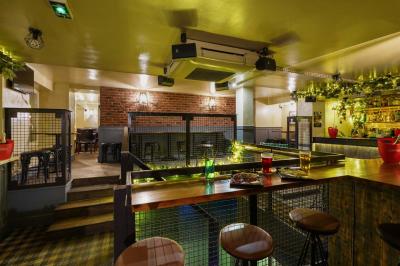 Miniature Location salle Paris 5 (Paris) - Le Pub Saint Michel #6 Salle de restaurant avec banquettes vertes, tables en bois garnies de plats variés et seau à champagne au centre.