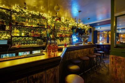 Miniature Location salle Paris 5 (Paris) - Le Pub Saint Michel #2 Salle de restaurant avec banquettes vertes, tables en bois garnies de plats variés et seau à champagne au centre.