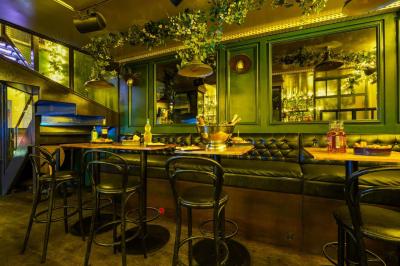 Miniature Location salle Paris 5 (Paris) - Le Pub Saint Michel #13 Salle de restaurant avec banquettes vertes, tables en bois garnies de plats variés et seau à champagne au centre.