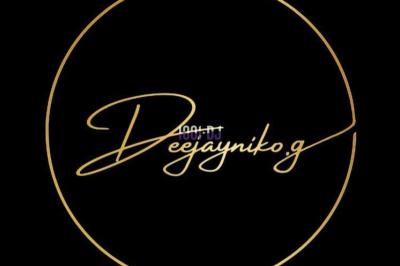 Un DJ mixant de la musique sur une table de mixage dans une salle éclairée par des lumières violettes.