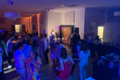 Un DJ mixant de la musique sur une table de mixage dans une salle éclairée par des lumières violettes.