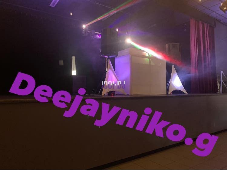 Installation de matériel de sonorisation et éclairage sur une scène avec jeux de lumière colorés.