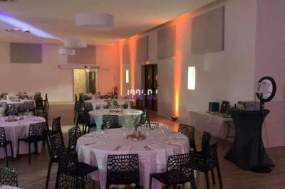 Un DJ mixant de la musique sur une table de mixage dans une salle éclairée par des lumières violettes.