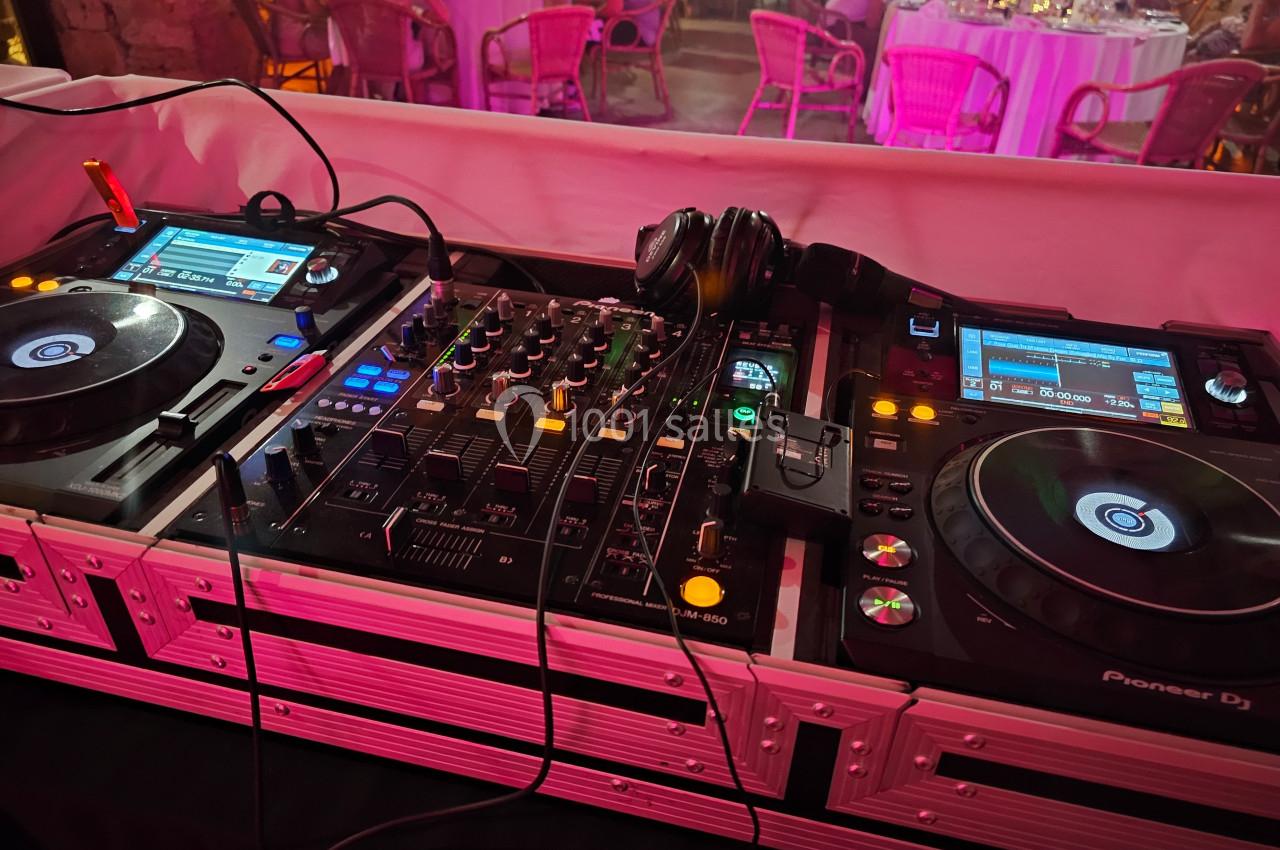 Deux platines DJ et une table de mixage avec des casques, installées dans un espace de réception éclairé.