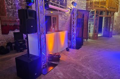 Vue depuis une scène sur une salle de réception où des invités dansent sous des lumières colorées.