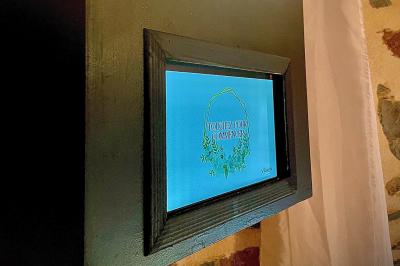 Salle de réception en pierre avec plafond en bois, tables rondes dressées et éclairage chaleureux.