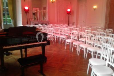 Façade d'un château éclairé par des lumières colorées, vue de nuit avec des silhouettes de personnes devant.