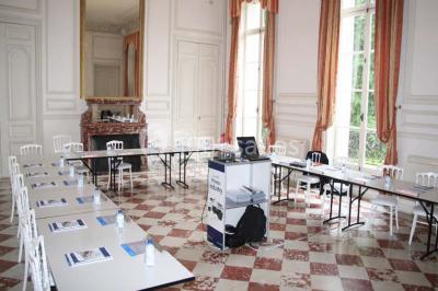 Façade d'un château éclairé par des lumières colorées, vue de nuit avec des silhouettes de personnes devant.