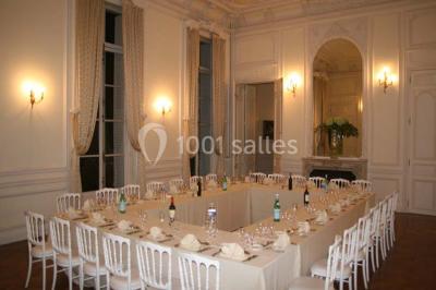 Façade d'un château éclairé par des lumières colorées, vue de nuit avec des silhouettes de personnes devant.