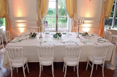 Façade d'un château éclairé par des lumières colorées, vue de nuit avec des silhouettes de personnes devant.