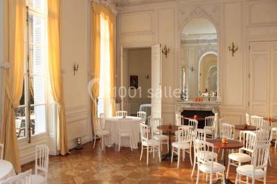 Façade d'un château éclairé par des lumières colorées, vue de nuit avec des silhouettes de personnes devant.