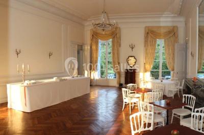 Façade d'un château éclairé par des lumières colorées, vue de nuit avec des silhouettes de personnes devant.