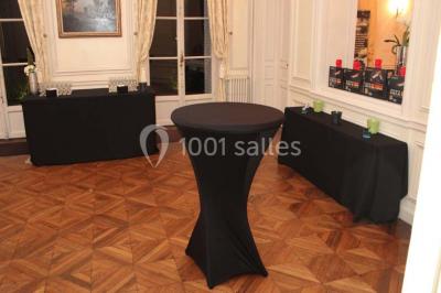 Façade d'un château éclairé par des lumières colorées, vue de nuit avec des silhouettes de personnes devant.