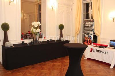 Façade d'un château éclairé par des lumières colorées, vue de nuit avec des silhouettes de personnes devant.